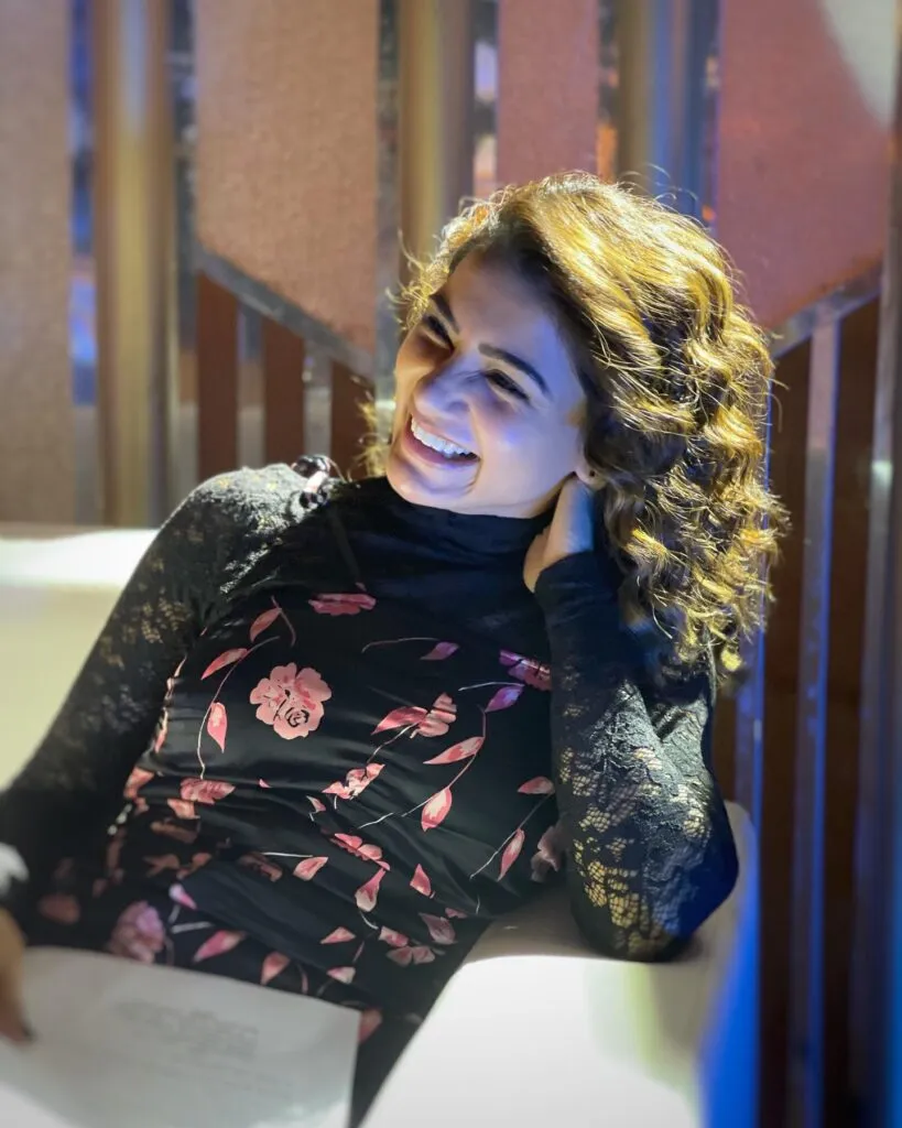 Smiling Samantha Ruth Prabhu in black and pink floral dress sitting on a couch - haircut bollywood