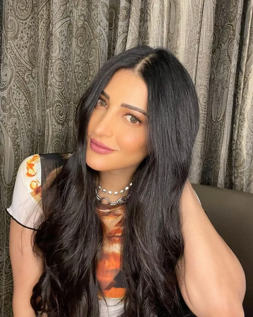 Shruti Haasan in multi color top with silver necklace posing for camera Shruti Haasan in multi color top with silver necklace posing for camera - haircut bollywood actress hairstyles