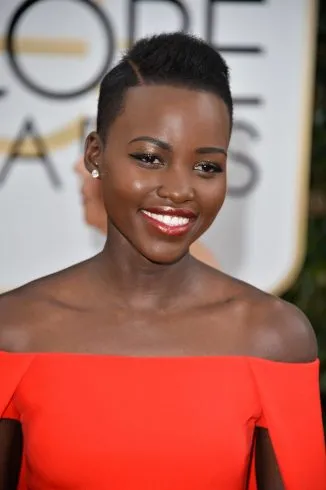 Lupita Nyong in orange off shoulder dress posing for camera - short hair hollywood celebrities