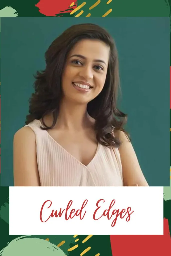 A smiling girl in pink cut sleeves top showing her curled edges A smiling girl in pink cut sleeves top showing her curled edges - Indian hairstyles for women