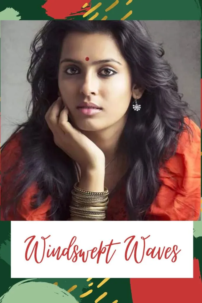 A girl in orange dress with drop earrings and bangles posing for camera and showing her windswept waves A girl in orange dress with drop earrings and bangles posing for camera and showing her windswept waves - Hairstyles for Indian Women