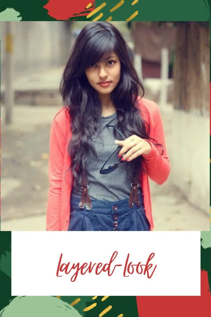 A girl in grey top with pink shrug holding goggles and showing her Layered-Look A girl in grey top with pink shrug holding goggles and showing her Layered-Look - Haircuts for Indian Women