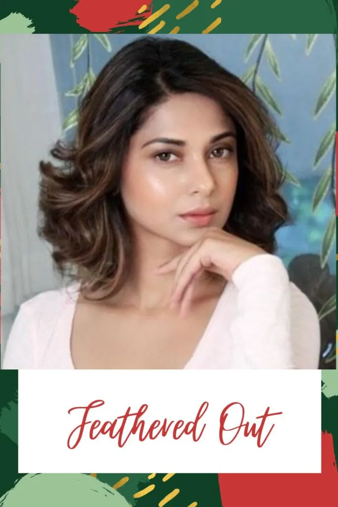 Girl in white deep round neck top posing for camera and showing her Feathered Out haircut Girl in white deep round neck top posing for camera and showing her Feathered Out haircut - Indian hair cut photos