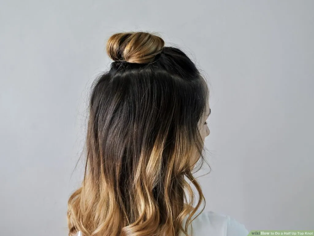 Woman ]in white top showing the side view of her Half Tie up Knot - long haircut 2022