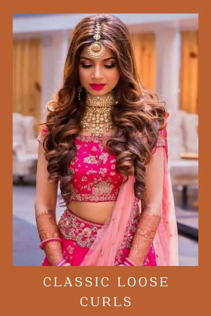 Woman in pink lehenga with golden jewellery and Classic Loose Curls hairstyle Woman in pink lehenga with golden jewellery and Classic Loose Curls hairstyle - Open curls and waves hairstyle