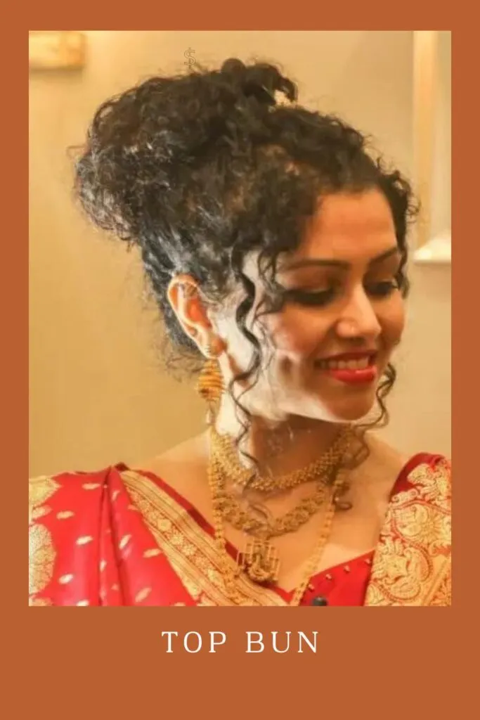 Smiling woman in red lehenga with golden jewellery and Top Bun hairstyle Smiling woman in red lehenga with golden jewellery and Top Bun hairstyle - curly hair with lehenga